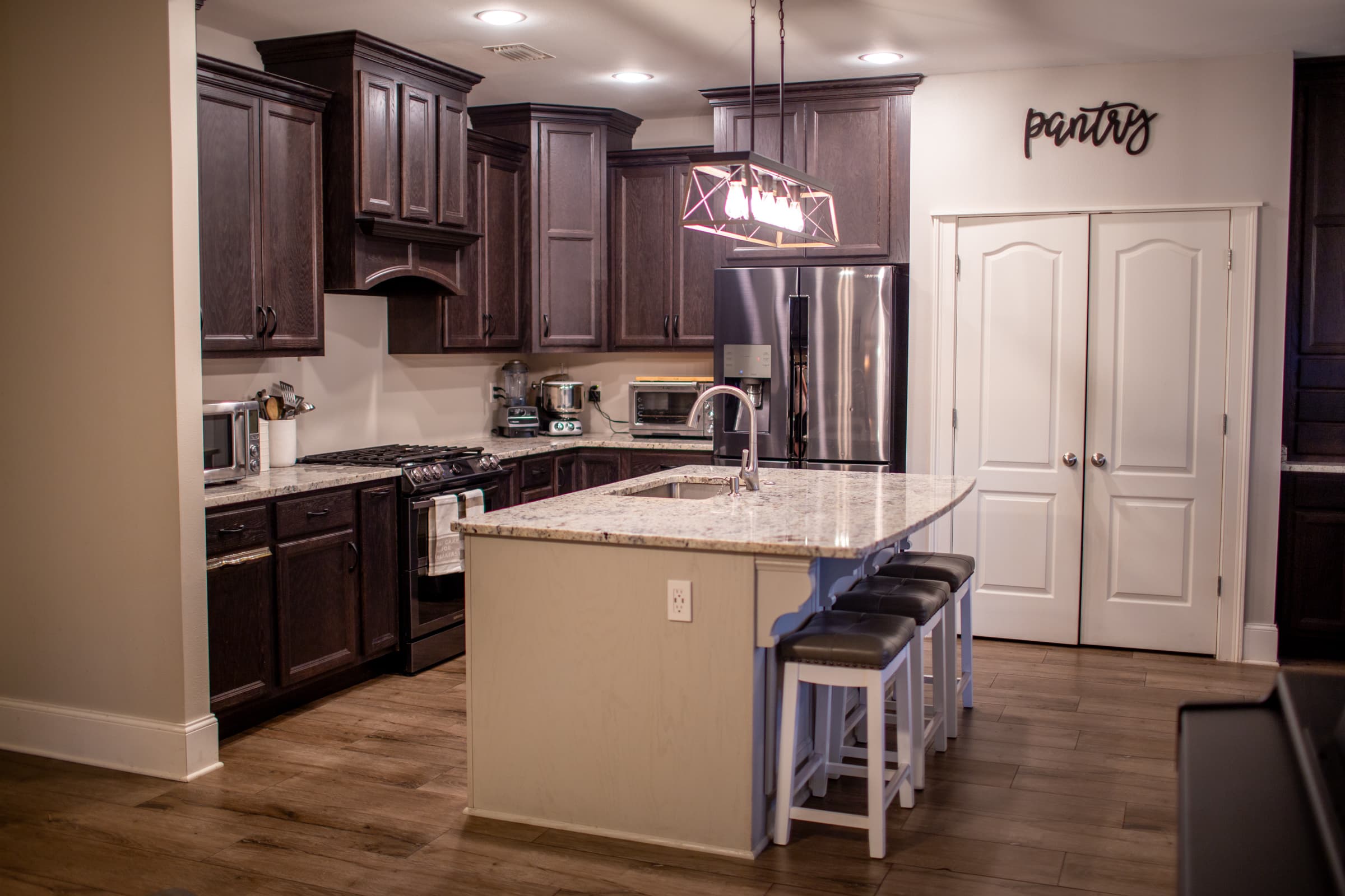 Kitchen with granite island, dark cabinetry, and bar seating