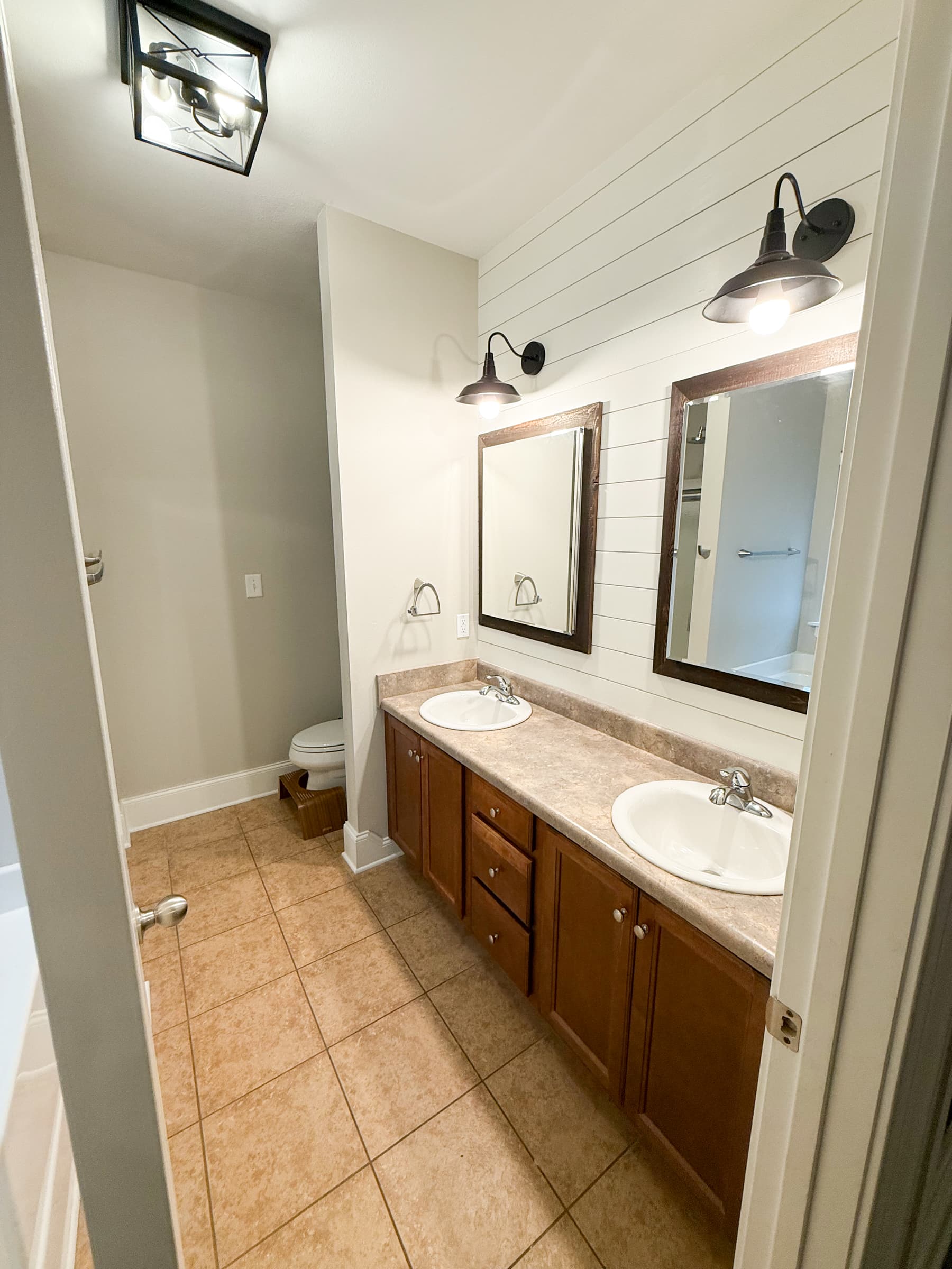 Primary bathroom with double vanity and shiplap accent wall
