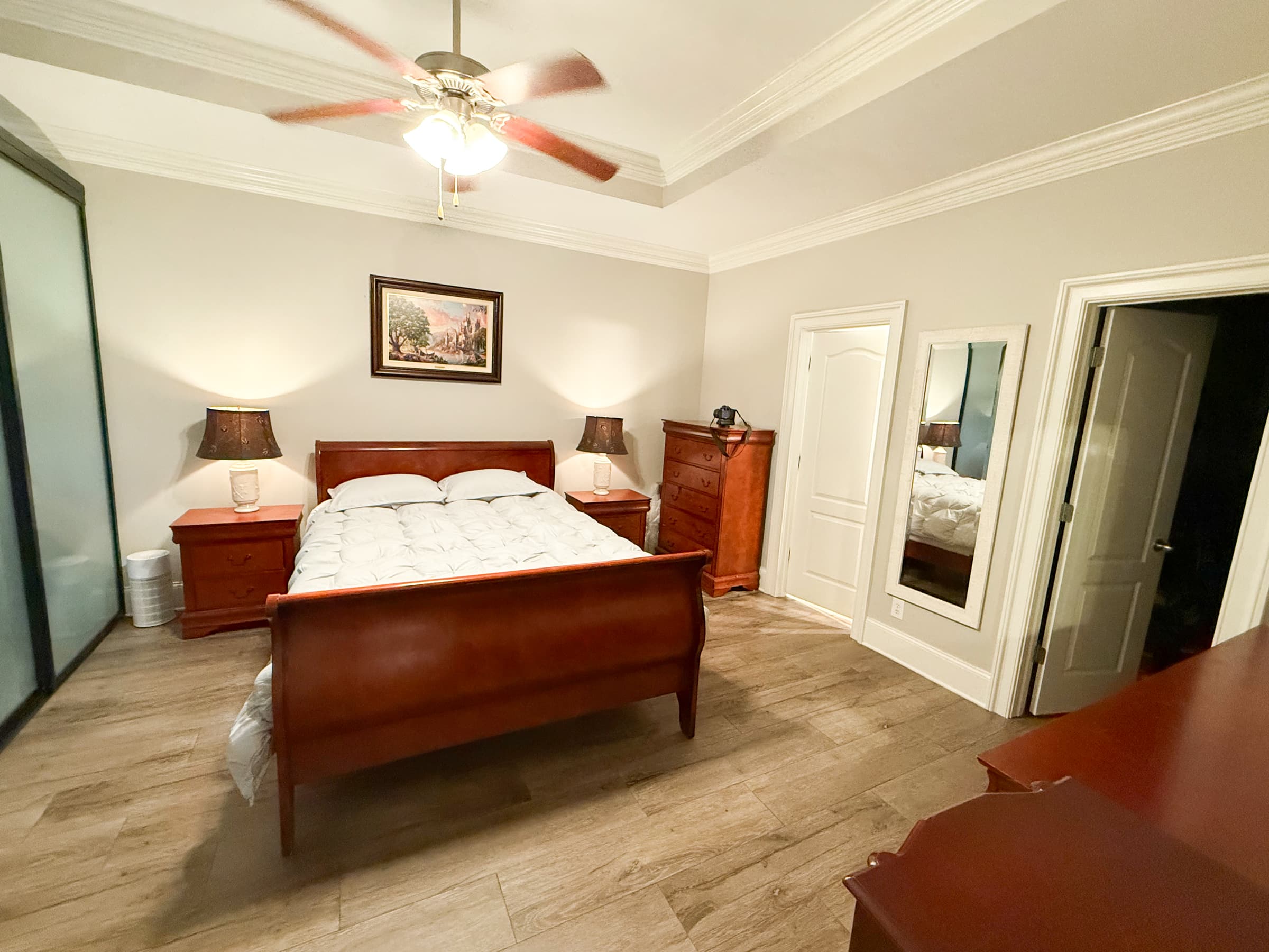 Primary bedroom with tray ceiling and ceiling fan