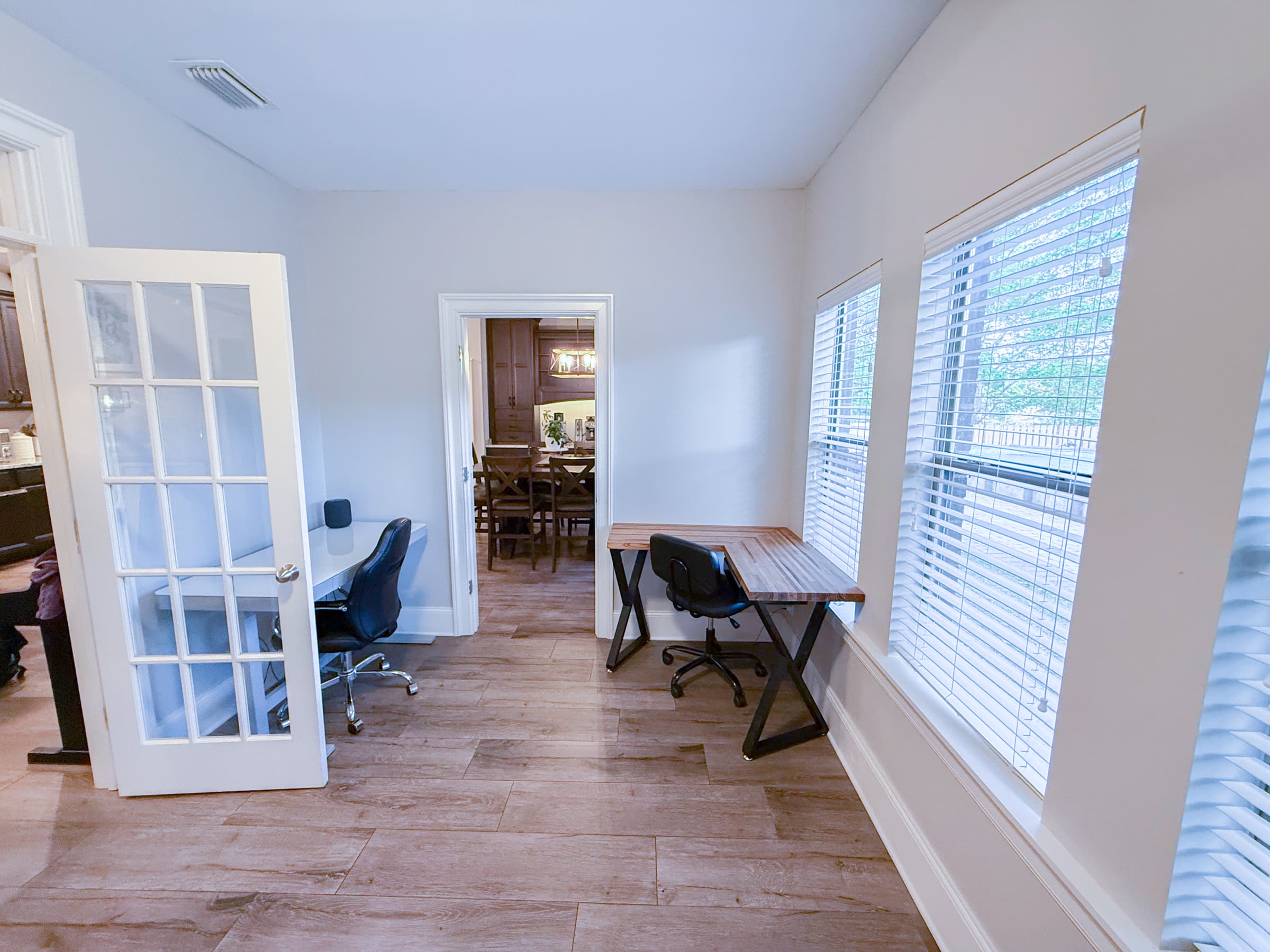 Sunroom workspace with dual desks and French door entry