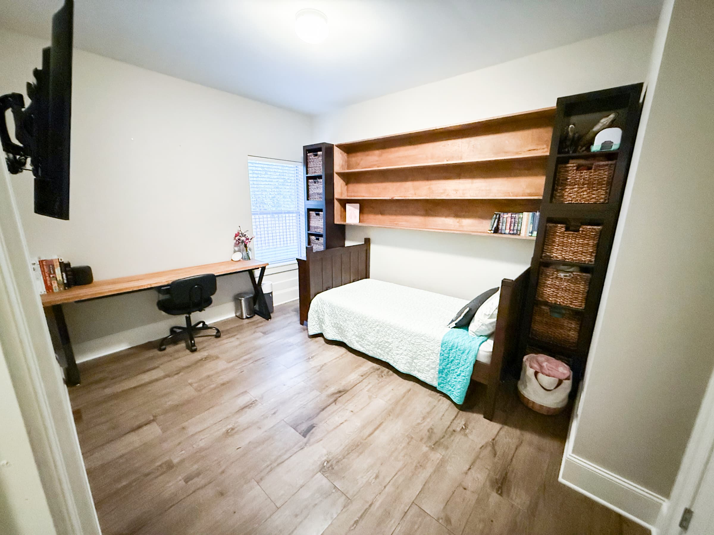 Bedroom with built-in desk, shelving, and daybed